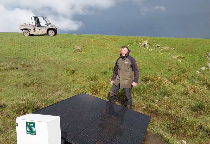 photo of farmer next to newly installed solar pump